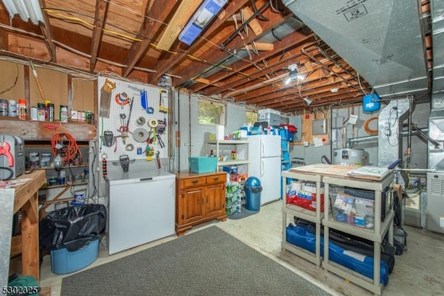 basement with a workshop area, electric panel, and white refrigerator