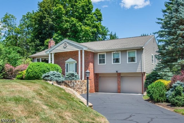 split foyer home with a garage and a front yard