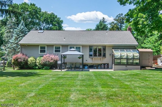 rear view of house with a yard, a gazebo, a patio area, and a sunroom