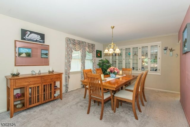 dining area with an inviting chandelier and light colored carpet