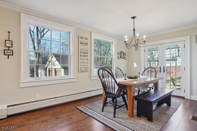 dining area with a chandelier, a baseboard heating unit, dark wood-style flooring, french doors, and ornamental molding