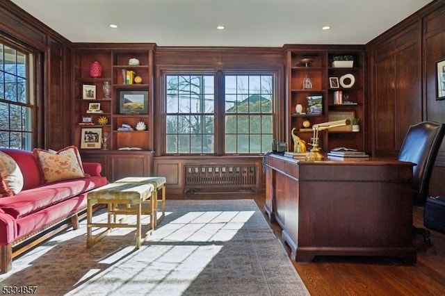 office featuring wood walls, radiator heating unit, dark wood finished floors, and a wealth of natural light