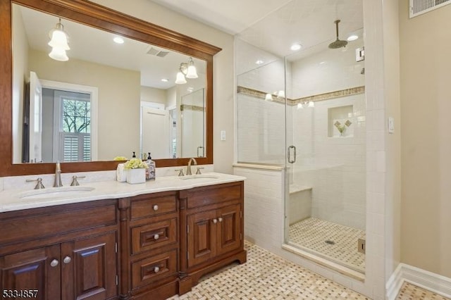 full bath featuring a stall shower, a sink, and visible vents