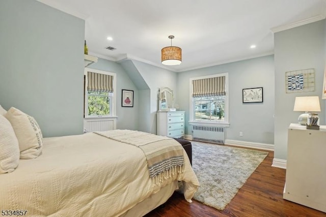 bedroom featuring wood finished floors, visible vents, baseboards, radiator, and crown molding