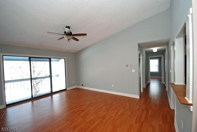 unfurnished room featuring wood-type flooring, vaulted ceiling, ceiling fan, and a textured ceiling