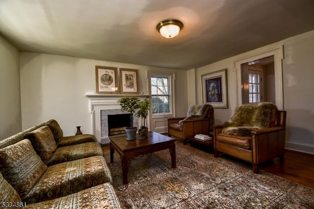 living room featuring a tiled fireplace and wood finished floors