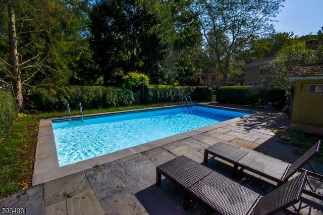 view of swimming pool featuring a patio and a fenced in pool