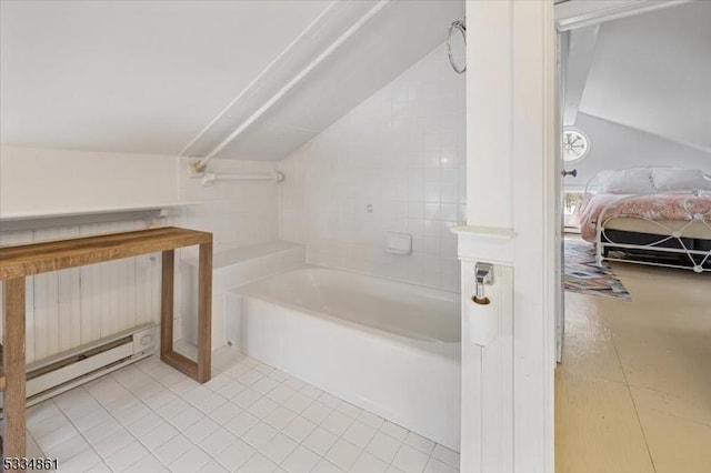 bathroom with tile patterned flooring, a baseboard radiator, vaulted ceiling, and a tub to relax in