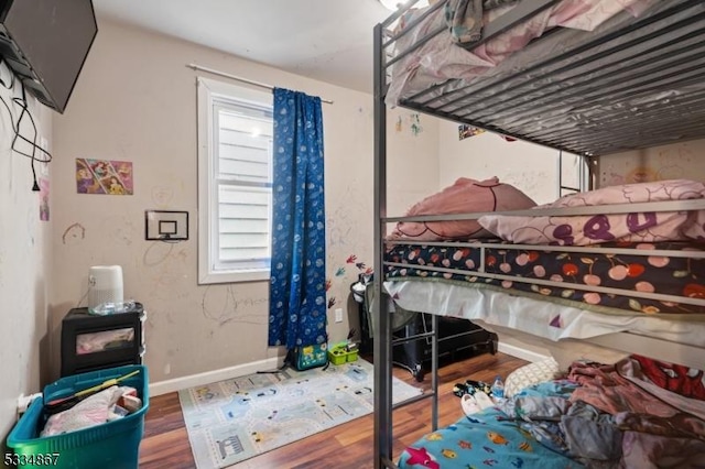 bedroom with multiple windows and hardwood / wood-style floors