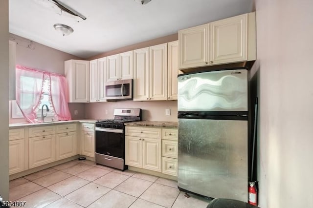 kitchen with sink, light tile patterned flooring, and appliances with stainless steel finishes