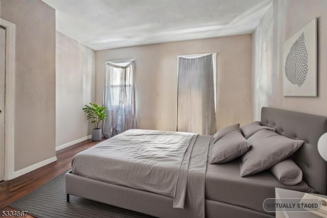 bedroom with dark hardwood / wood-style flooring