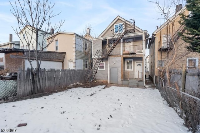 snow covered house featuring a balcony