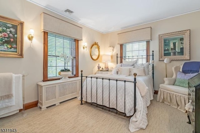 bedroom with multiple windows and radiator heating unit