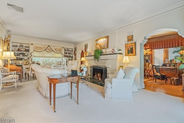 living room with ornamental molding, carpet, and a healthy amount of sunlight