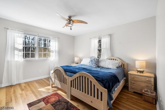 bedroom featuring a ceiling fan, baseboards, and wood finished floors