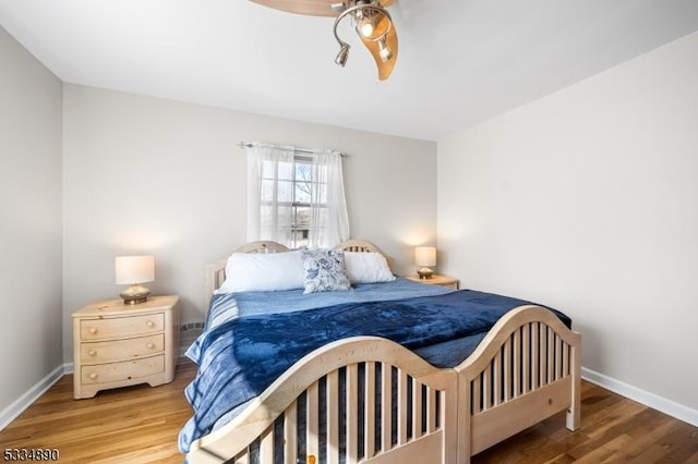 bedroom with ceiling fan, baseboards, and wood finished floors