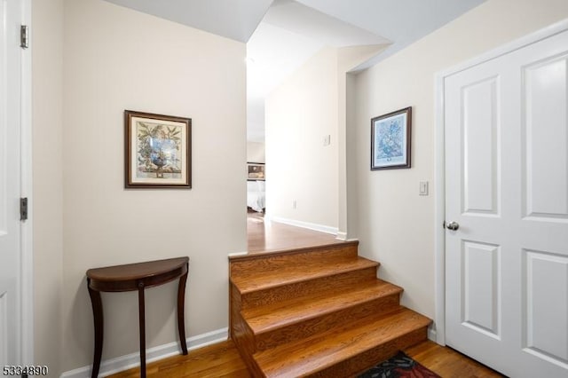 stairs with wood finished floors and baseboards