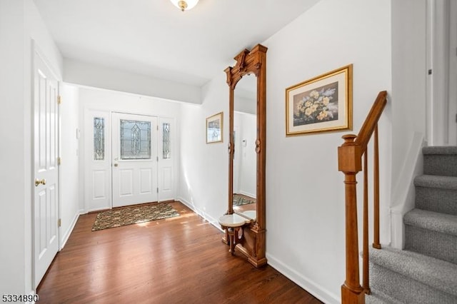 entrance foyer with dark wood-style flooring, baseboards, and stairs