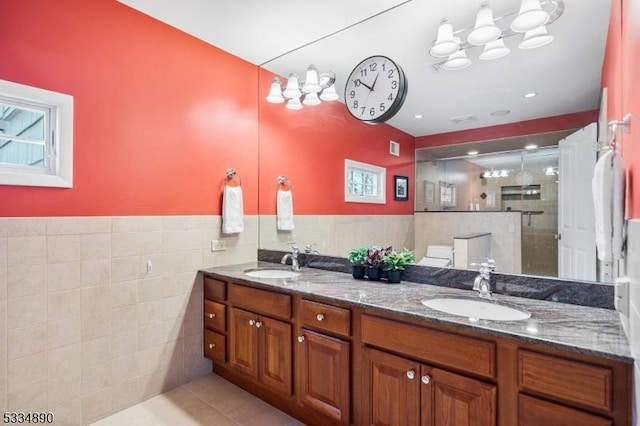 full bath featuring a stall shower, a sink, tile walls, and tile patterned floors