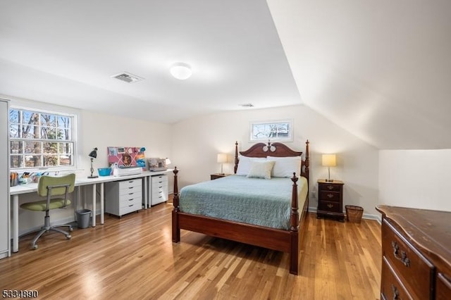 bedroom featuring visible vents, vaulted ceiling, light wood-style flooring, and baseboards