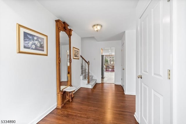 hall featuring dark wood-style floors, stairs, and baseboards