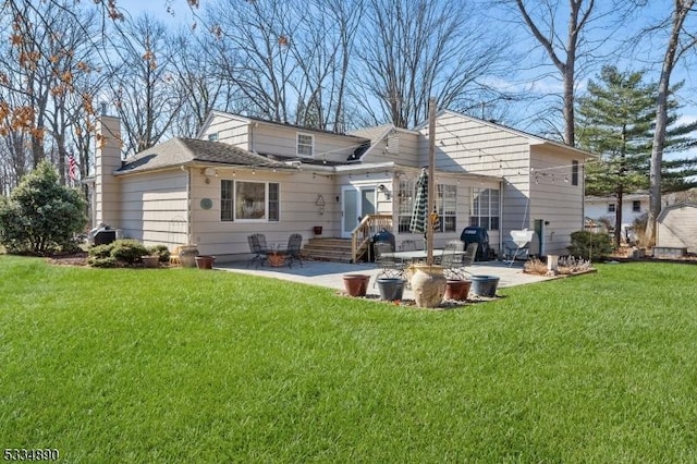 rear view of property featuring a patio area, a lawn, and a chimney