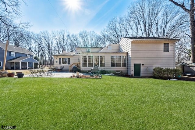 rear view of house with a yard and a patio