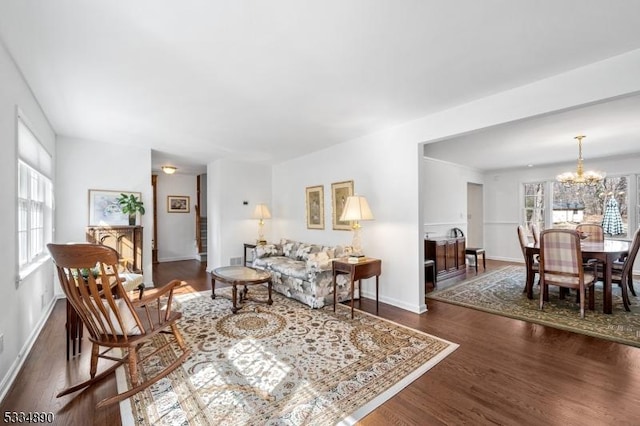 living room featuring baseboards, an inviting chandelier, and wood finished floors