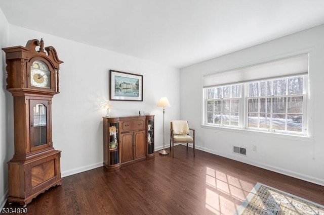 living area featuring dark wood-style floors, visible vents, and baseboards