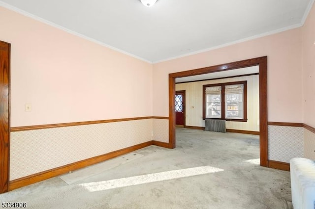 empty room featuring crown molding, radiator, and light carpet