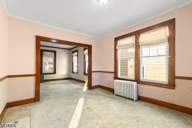 carpeted empty room featuring ornamental molding and radiator