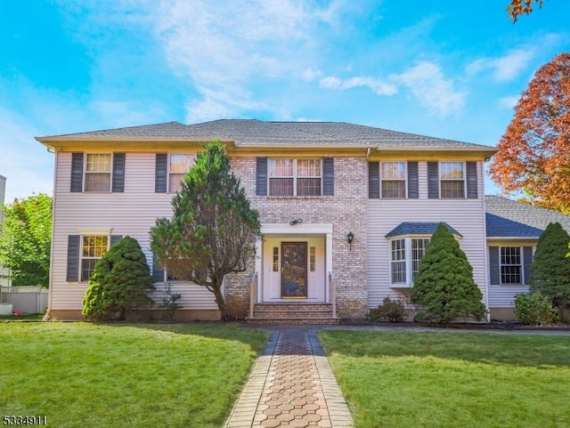 colonial-style house featuring a front lawn