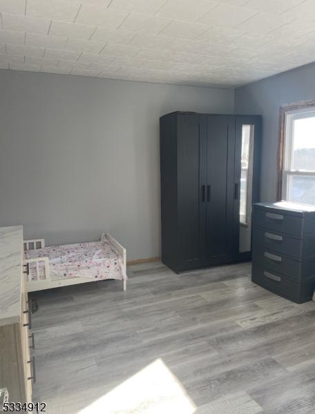 unfurnished bedroom featuring light wood-style flooring and baseboards