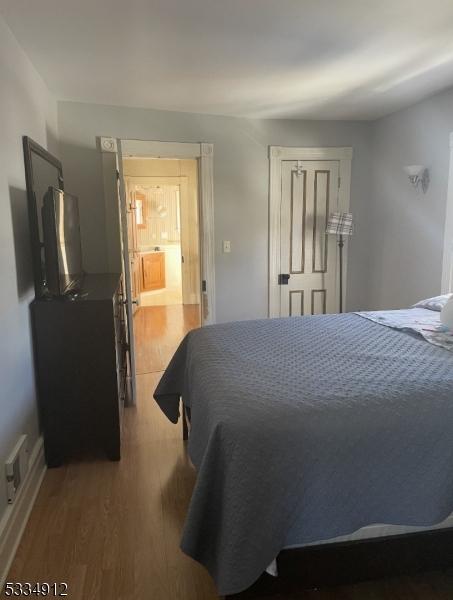 bedroom with light wood-style floors and visible vents