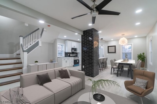 living room featuring decorative columns and ceiling fan