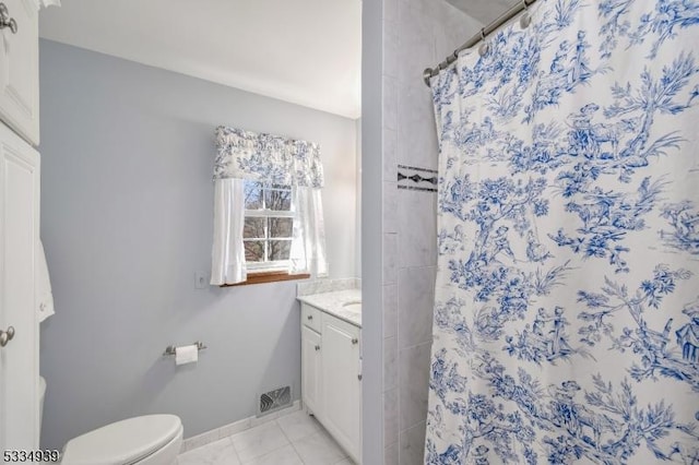 bathroom featuring vanity, walk in shower, tile patterned floors, and toilet