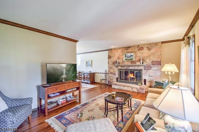 living room with ornamental molding, a fireplace, and hardwood / wood-style floors