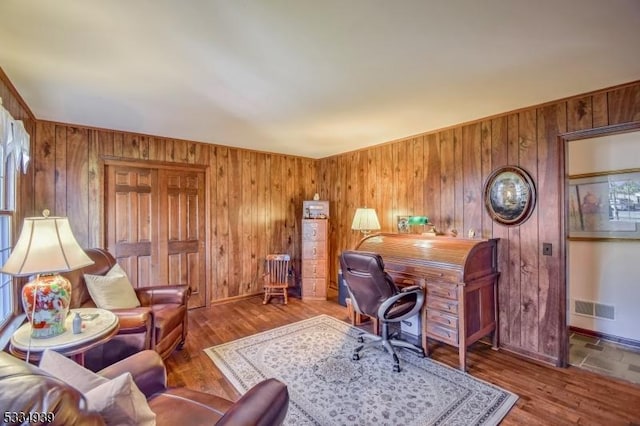 office space with hardwood / wood-style flooring and wood walls