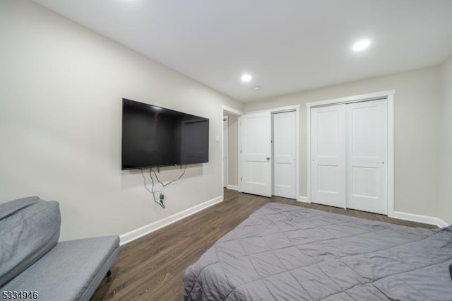 bedroom featuring dark hardwood / wood-style floors and multiple closets