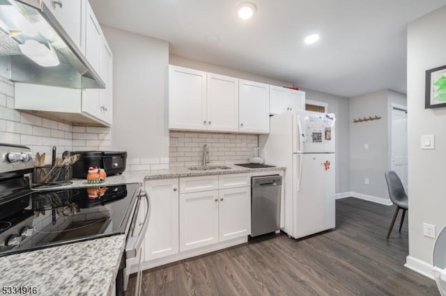 kitchen with sink, white cabinetry, light stone counters, appliances with stainless steel finishes, and dark hardwood / wood-style flooring