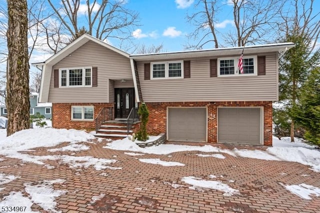 bi-level home featuring brick siding and an attached garage