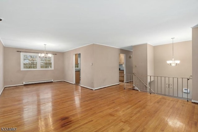 empty room featuring baseboards, light wood-style flooring, a baseboard heating unit, and a notable chandelier