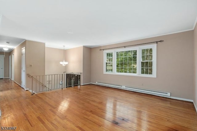 unfurnished room featuring a baseboard heating unit, crown molding, wood finished floors, and a chandelier