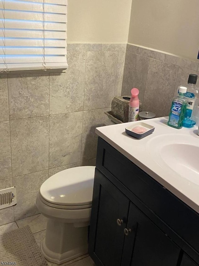 bathroom featuring vanity, tile walls, tile patterned floors, and toilet