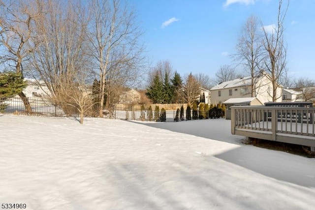 yard covered in snow with a wooden deck