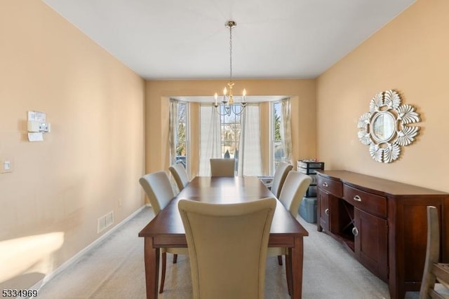 carpeted dining space with an inviting chandelier