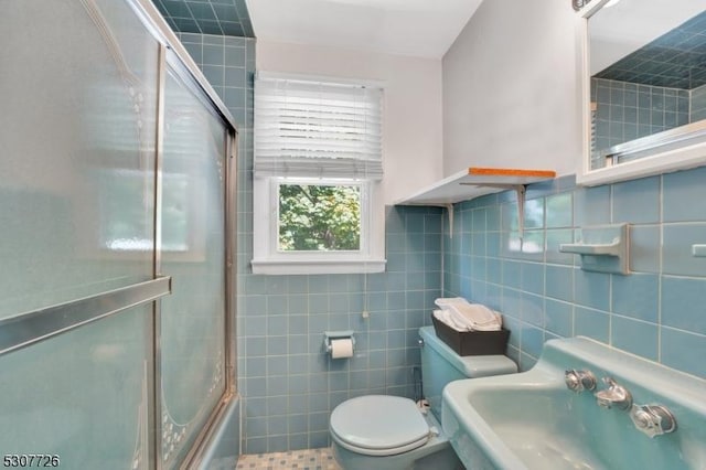 full bathroom with enclosed tub / shower combo, sink, tile walls, and toilet