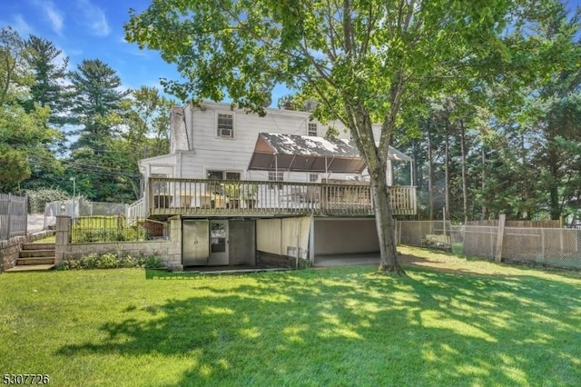 rear view of house featuring a deck and a lawn