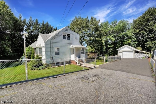 view of front of home featuring a garage, an outdoor structure, and a front lawn