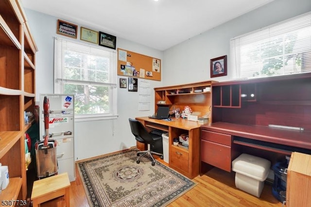 home office with light hardwood / wood-style flooring